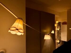 Wit lichtsnoer met creme lampenkapjes hangend in een kamer