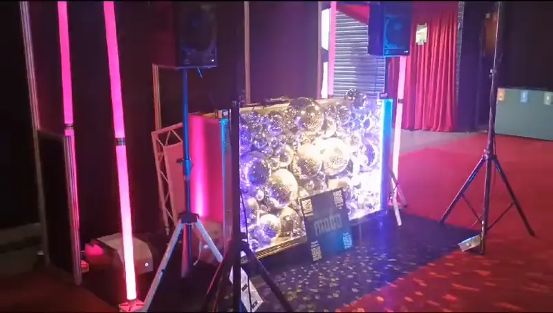 Een gifje van een discoballen dj meubel op een beurs, waarbij de camera er voorlangs omheen loopt en de spiegeltjes schitteren door het licht