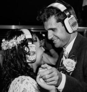 Witte Silent Disco koptelefoons op de hoofden van een net getrouwd stel