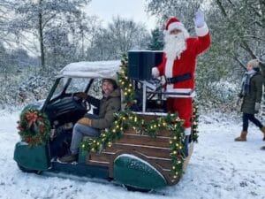 Een vintage golfkar met kerstversiering en kerstman erop