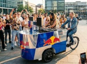 Een gewrapte dj bakfiets met red bull branding en publiek eromheen